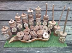 an arrangement of wooden spinning wheels and numbers on a green mat with wood pegs