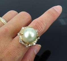 Title:                              Vintage 13.8mm South Seas Button Pearl & 1.08ct Diamond 18K Yellow Gold Ring 6   Age/Markings:             Vintage                                         Diamonds:                   Approximately 1.08 carats of diamonds, H to I color, SI clarity   Gemstones:                 Approximately 13.8mm large button shape cultured saltwater pearl, golden creamy white color, very good luster   Metal:                            18K yellow gold              Weight: 12.4 grams   Measurements: 21.2mm wide, finger size 6   Condition: Good condition, rich patina on the gold   Description: Vintage diamond & pearl 18K yellow gold ring featuring an unusually large size button shape cultured saltwater pearl. This fine ring was handmade around the pearl with a mixed size di Pearl And Diamond Ring Antique, Antique Jewelry Rings, Saltwater Pearls, Fine Ring, 18k Yellow Gold Ring, South Seas, The Pearl, Yellow Gold Ring, Rose Color