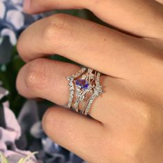 a woman's hand wearing a ring with an amethorate and diamonds