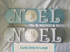 two wooden signs that say noel and noel with sand dollars on the bottom one says noel