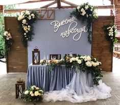 the table is set up with white flowers and greenery