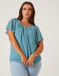 If you are looking for a simple, flattering blouse for work or school, look no further. The Curve Chiffon Flutter Sleeve Blouse is the ultimate smart-casual top. This top features short flutter sleeves, a button at the back of the neck, and a gathered hem at the bottom. The material is a non-stretchy chiffon that is lined except for on the sleeves. This blouse is made from 100% polyester and the lining is 95% polyester and 5% spandex. Hand wash cold. Imported. Model is wearing a size 1XL. Flowy Short Sleeve Blouse For Work, Flowy Blouse With Flutter Sleeves For Work, Smart Casual Tops, Blouse For Work, School Look, Flutter Sleeve Blouse, Work Blouse, Flutter Sleeves, Casual Top