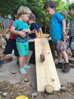 kids playing with a wooden board on the ground