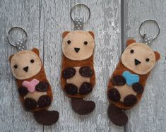 three stuffed animals are hanging from key chains