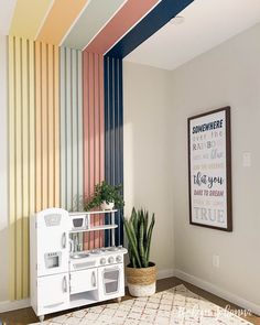 a white stove top oven sitting next to a rainbow painted wall in a living room