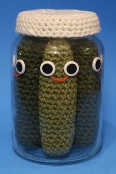 two crocheted items in a jar with googly eyes