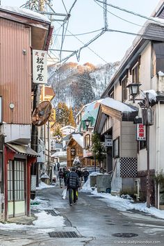 people walking down an alley way in the snow