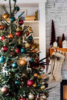 a decorated christmas tree in front of a fireplace