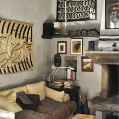 a living room filled with furniture next to a fire place and a painting on the wall