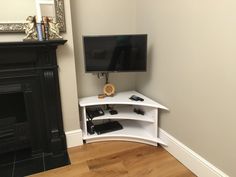 a flat screen tv sitting on top of a white shelf next to a fire place