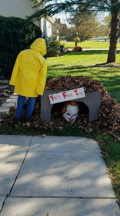 a person in a yellow raincoat standing next to a dog house with a sign on it