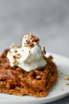 a waffle topped with whipped cream and pecans