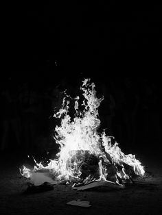 a black and white photo of a fire in the dark