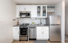 a kitchen with stainless steel appliances and white cabinets