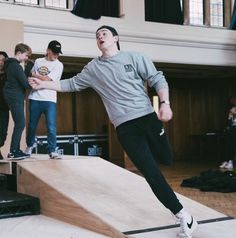 a man riding a skateboard up the side of a wooden ramp in a building