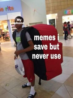 a man carrying a large red bag in the middle of a shopping mall with words written on it