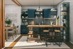 a kitchen with blue cabinets and stools next to a wooden table in front of a white brick wall