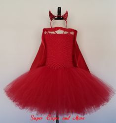 a red dress hanging on a white wall with the words super cute and more written below it