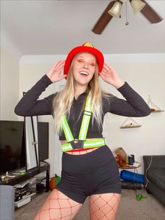 a woman in fishnet stockings and suspenders poses for the camera with her hands on her head