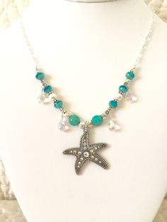 "Sparkling \"Star of the Sea\" beaded silver chain necklace featuring gorgeous 1 1/4\" x 1 3/8\" rhinestone starfish antique silver pendant. Surrounding the charm two-color Aqua designer Czech glass beads, lovely white Swarovski crystal pearls, turquoise Czech table cut beads, wire wrapped iridescent Czech glass teardrops, Czech vitrail (rainbow iridescent) beads, pewter and silver spacer beads. All strung on a pretty sparkly Sterling silver plate cable chain with unique easy to use handmade sil Silver Necklaces With Star Charm And Round Beads, Silver Necklace With Star Charm And Round Beads, Beach Jewelry In Silver With Rhinestones, Silver Rhinestone Beach Jewelry, Bohemian Silver Jewelry With Starfish Charm, Beach Silver Jewelry With Rhinestones, Bohemian Silver Necklace With Starfish Charm, Silver Rhinestone Jewelry For The Beach, Silver Beaded Ocean-inspired Jewelry