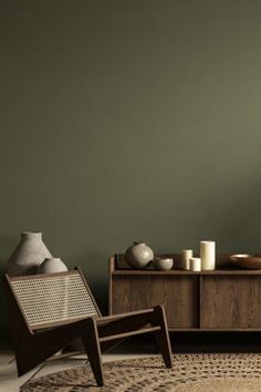 a living room with green walls and rugs on the floor in front of a coffee table