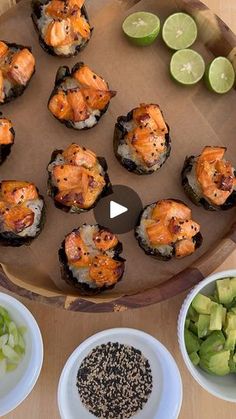 a wooden tray topped with lots of sushi and other foods on top of it