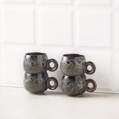 three coffee mugs sitting next to each other on a counter