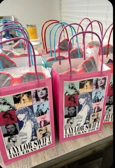 pink and blue shopping bags with pictures of taylor swift on them are sitting on a table