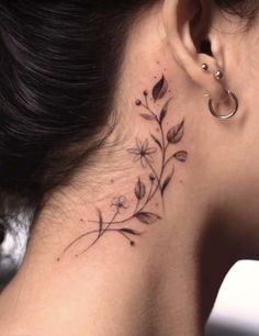 a woman's behind the ear tattoo with flowers