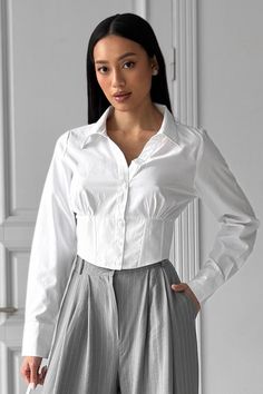 Crop Button Collared Shirt, White Cotton Shirt, Long Sleeve Blouse Top, Fitted Cropped Top, Gifts for Women, Cropped Shirt for Women White basic corset-type shirt. The front part with a corset-type insert, and an elastic band on the back. Silhouette: semi-adjacent Fastening: buttons and loops Neck: shirt Pockets: none Decorative elements: a shaped belt with a "cat's whisker" on the front, and an elastic band insert on the back. Fabric: cotton Composition: 99% cotton, 1% elastane Color: white Siz White Cropped Long Sleeve Shirt With Buttons, Fitted Cropped Long Sleeve Shirt For Daywear, White Cropped Shirt With Long Sleeves And Buttons, Fitted Button-up Shirt With Padded Blouse, Elegant White Button-up Cropped Shirt, Fitted Tops With Button Closure And Collared Neckline, White Long Sleeve Cropped Shirt With Button Closure, Fitted Blouse With Back Button Closure For Daywear, Fitted Collared Blouse For Daywear