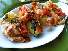 four stuffed shells with sauce and spinach on a plate