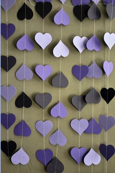 purple and black hearts hanging from strings on a wall with the words amazon above them