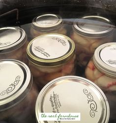 several jars filled with pickles sitting on top of a stove burner next to each other