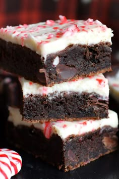 three chocolate peppermint brownies stacked on top of each other with candy canes