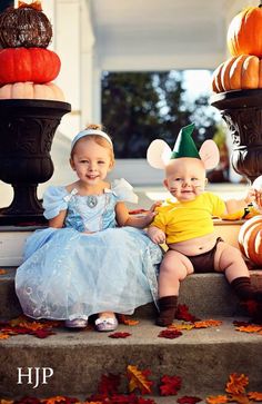 two children dressed up in costumes sitting on steps