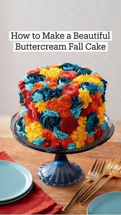 a multicolored cake sitting on top of a table next to plates and forks