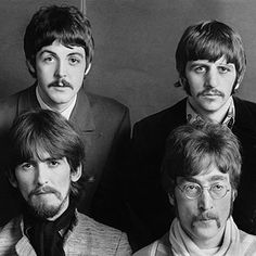 the beatles are posing for a portrait in black and white, with one man looking at the camera