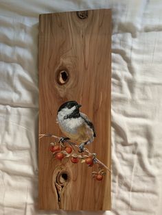 a bird sitting on top of a piece of wood next to some berries and nuts