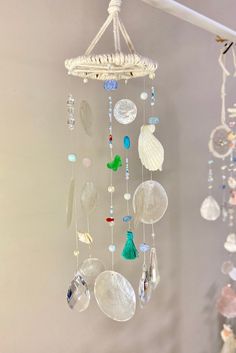 a wind chime hanging from the ceiling with shells and seashells on it