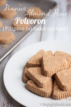 a white plate topped with heart shaped cookies next to a baking pan filled with cookies