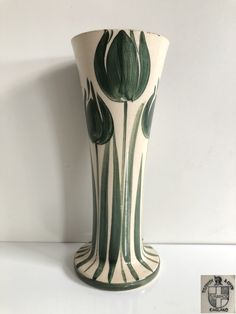 a green and white vase sitting on top of a table