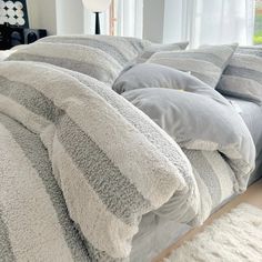 a bed covered in grey and white blankets