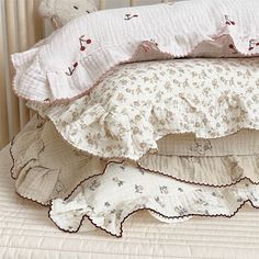 three pillows stacked on top of each other in front of a crib with a teddy bear