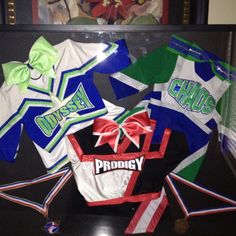 various cheer uniforms are on display in a case