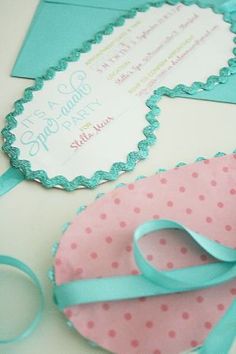 a pink and blue heart shaped cake next to a card with a ribbon on it