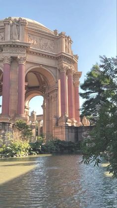 an ornate building with columns and arches over water