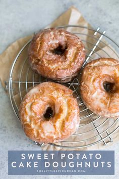 three glazed donuts sitting on top of a metal rack