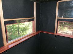 an empty room with three windows and no curtains on the inside, in front of some trees