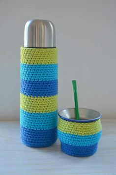 a blue and yellow cup with a straw in it sitting next to a metal container