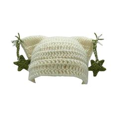 two white crocheted pillows with green stars on the bottom and one is made out of